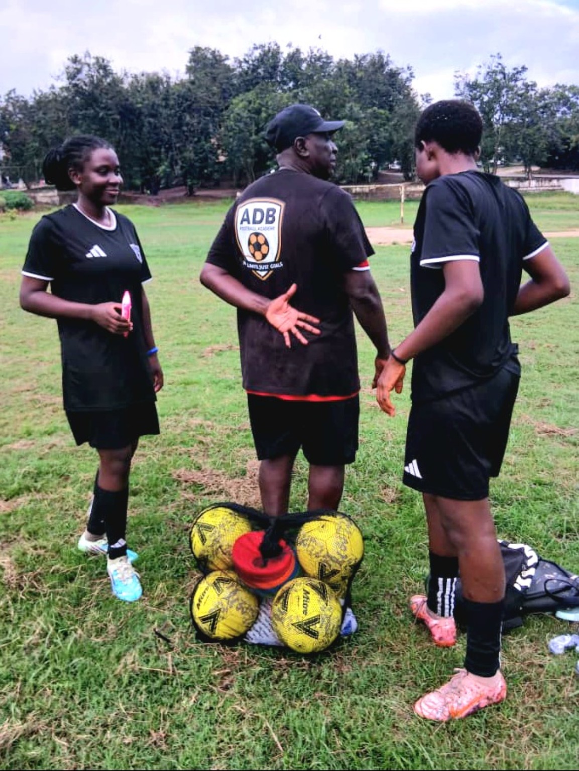 Academy coach speaking with two players